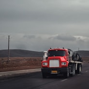 a red semi truck driving down a road