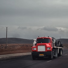 a red semi truck driving down a road