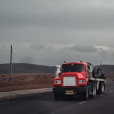 a red semi truck driving down a road