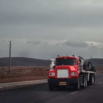 a red semi truck driving down a road
