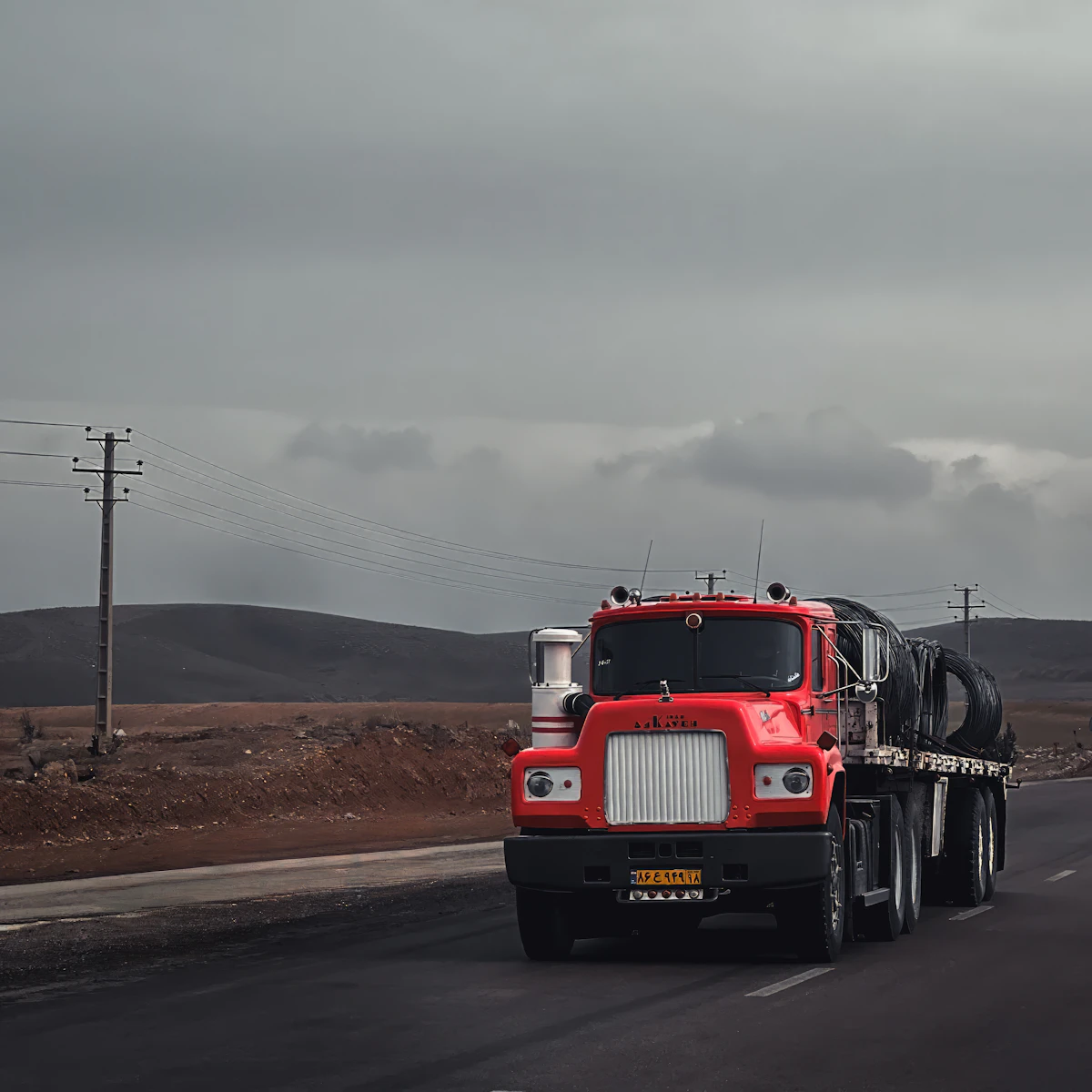 Red semi truck driving down a road