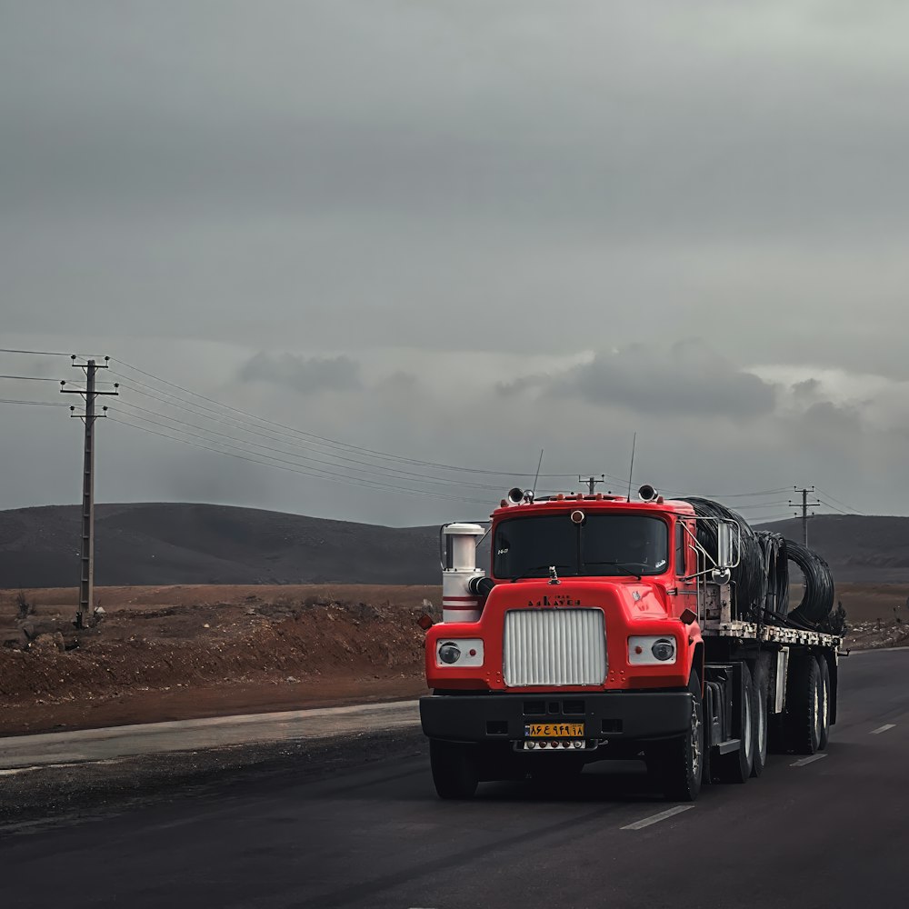 a red semi truck driving down a road