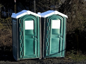 a couple of green portable toilets sitting next to each other