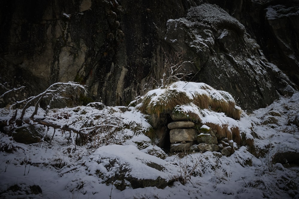 a pile of rocks covered in snow next to a mountain