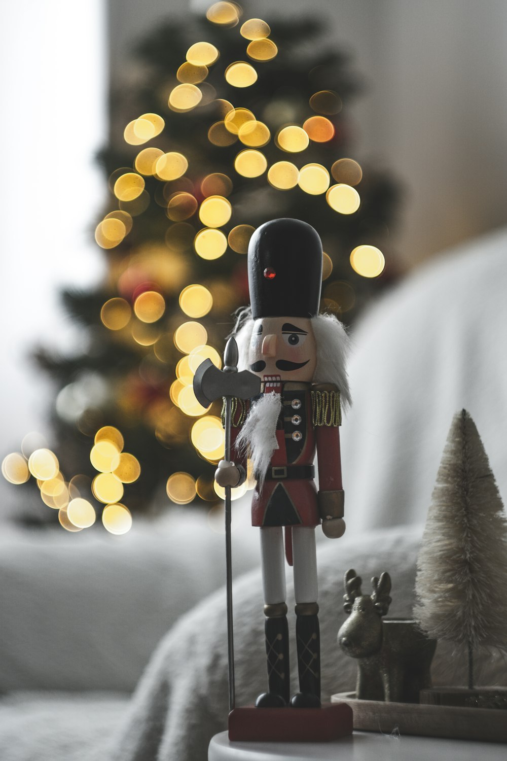 a nutcracker is standing next to a christmas tree