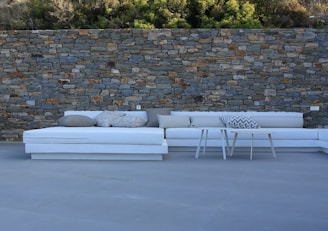 Modern outdoor seating area surrounded by natural stone walls.