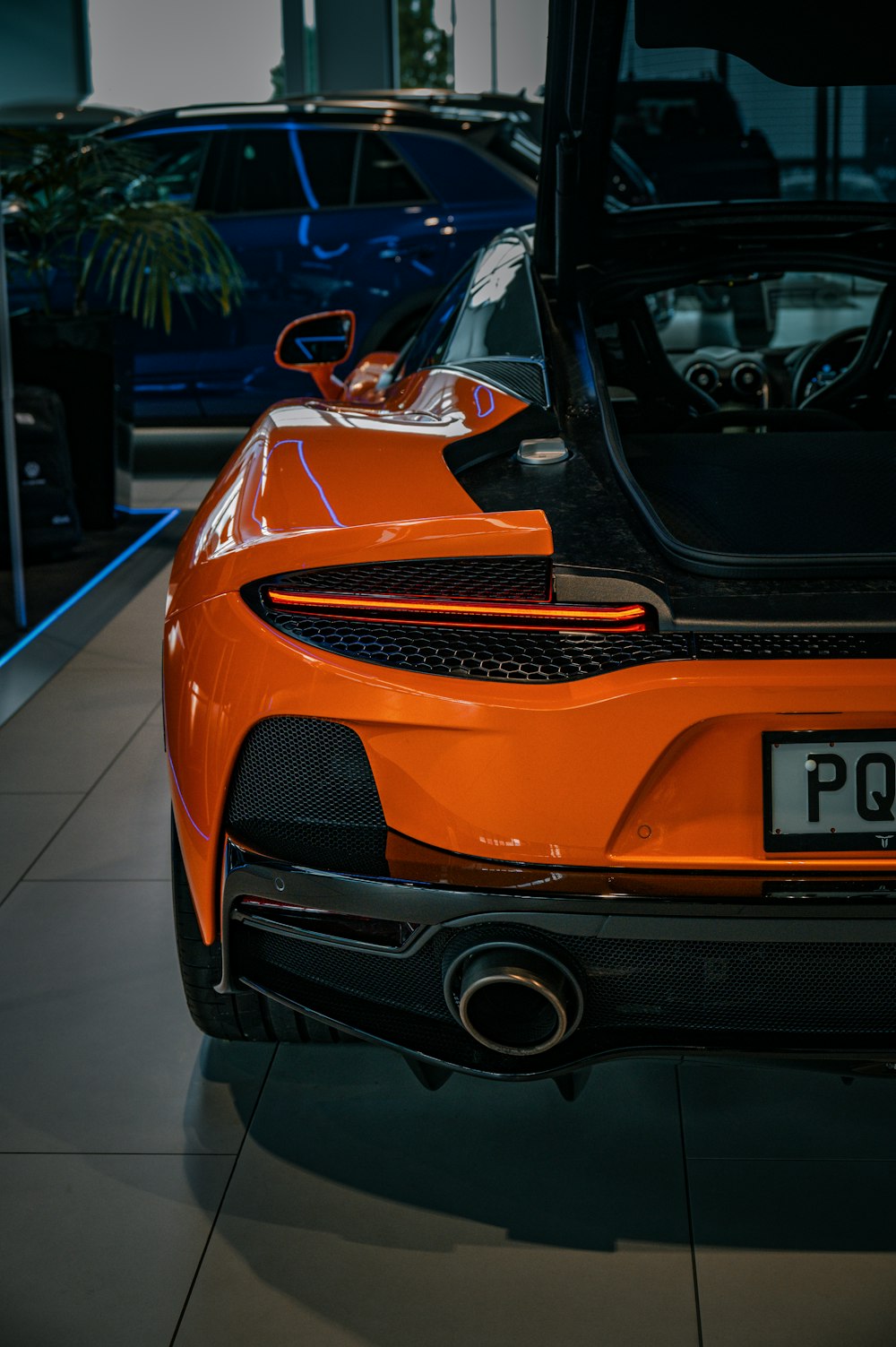 an orange sports car parked in a showroom