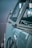 A vintage car with a focus on its side and distinctive logo on the front, featuring a classic, chrome-accented design.