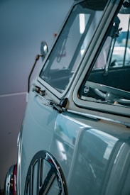 A vintage car with a focus on its side and distinctive logo on the front, featuring a classic, chrome-accented design.