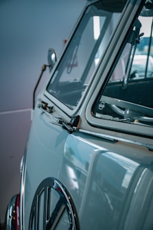 A vintage car with a focus on its side and distinctive logo on the front, featuring a classic, chrome-accented design.