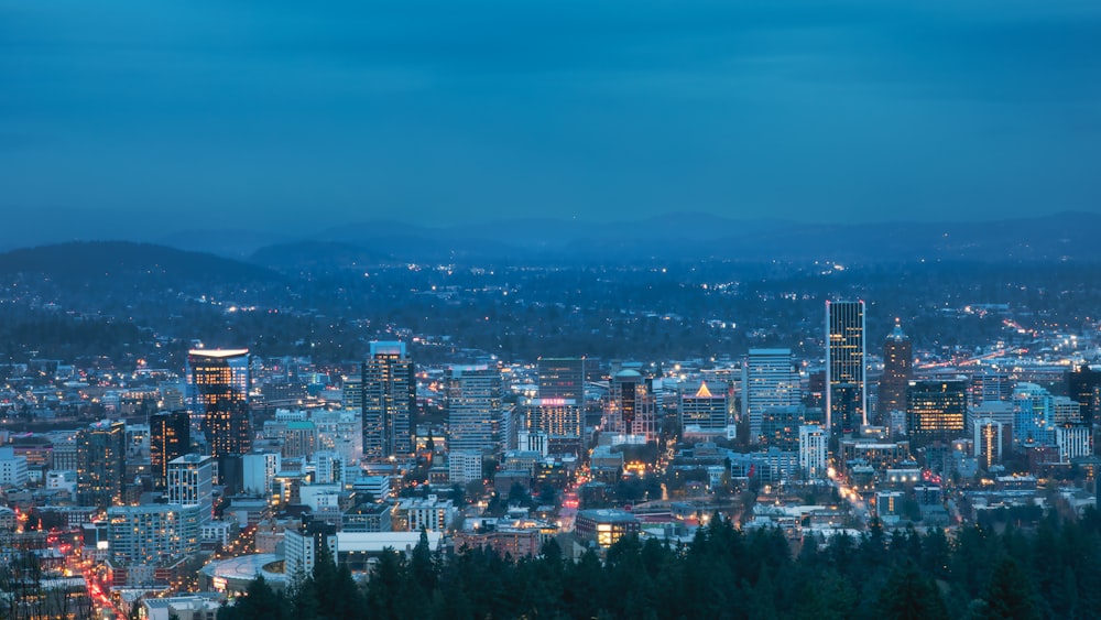 Blick auf eine Stadt bei Nacht von der Spitze eines Hügels