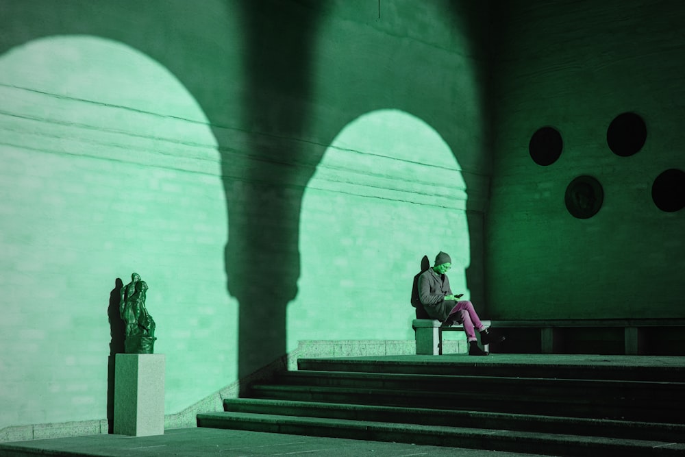 a man sitting on a bench in front of a building