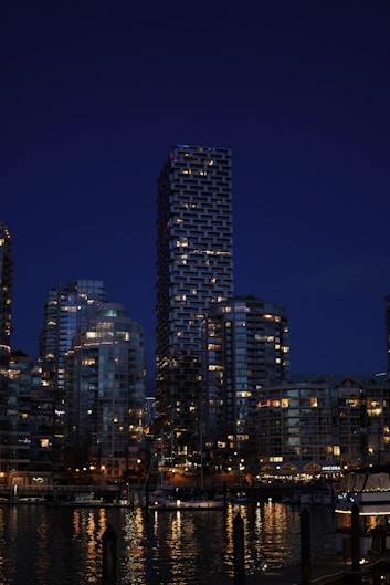 a city skyline at night with a boat in the water