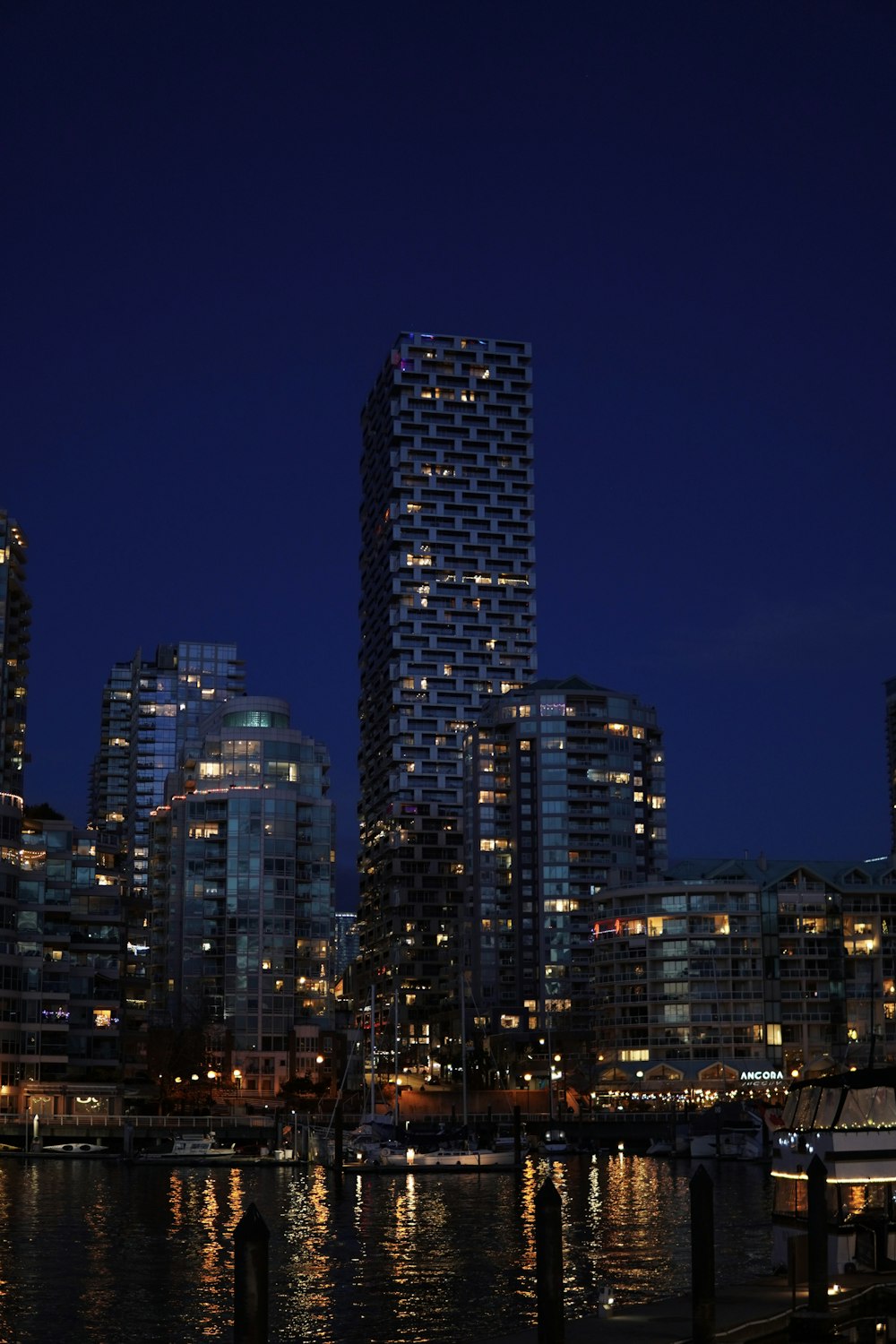 a city skyline at night with a boat in the water