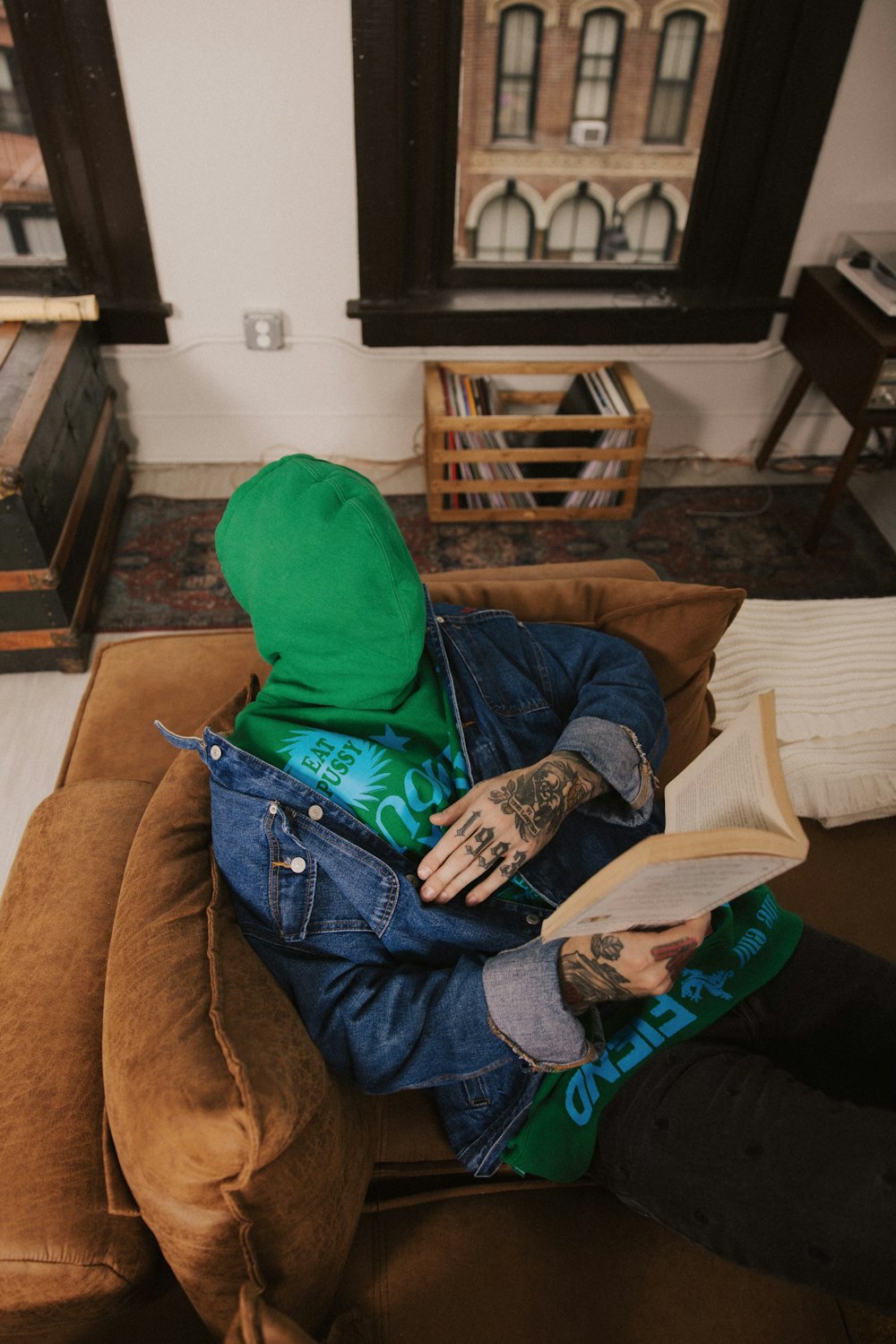 una persona seduta su un divano con un libro