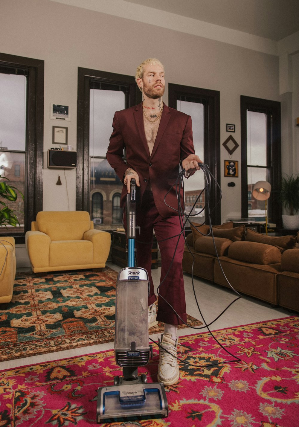 a man in a red suit is using a vacuum