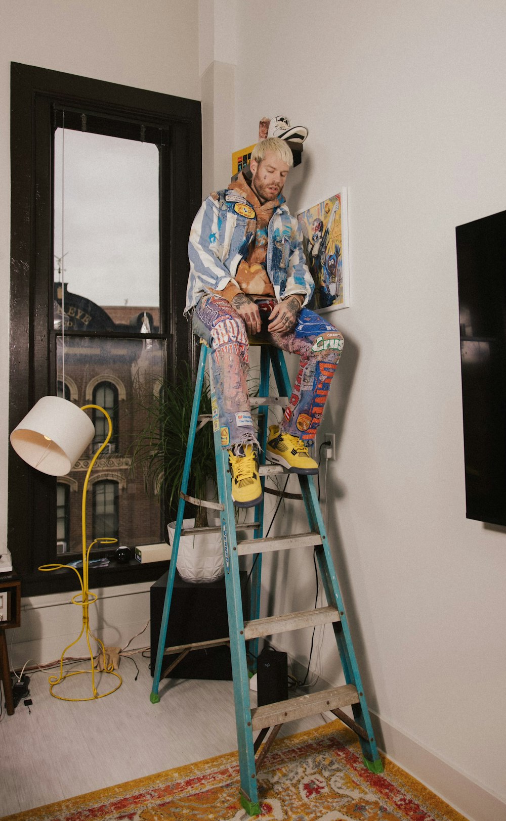 a man sitting on top of a blue ladder