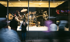 Visitors admiring starry night clockwork's steampunk jewelry at an outdoor art fair booth during golden hour.