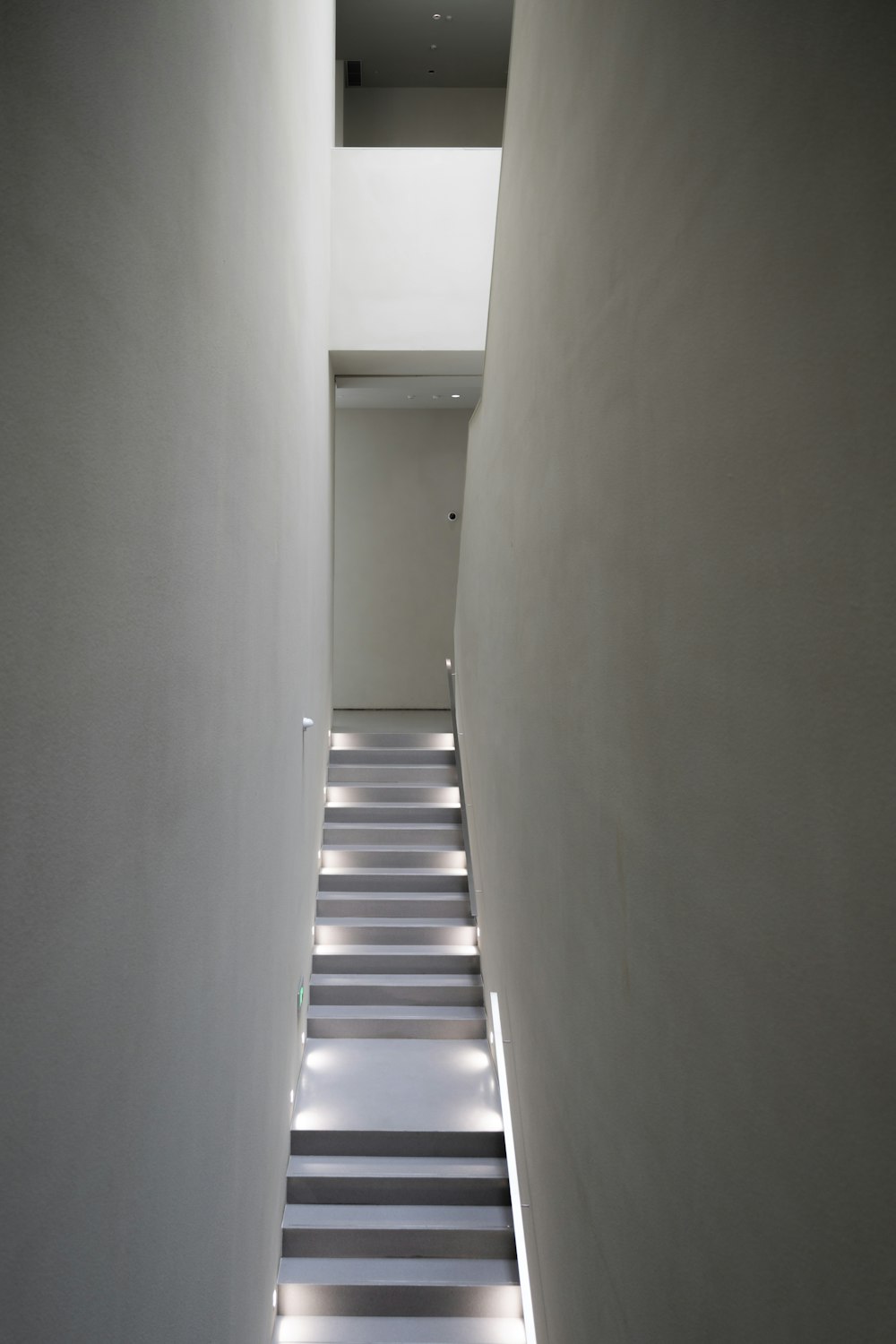 a long narrow hallway with white walls and black and white striped flooring