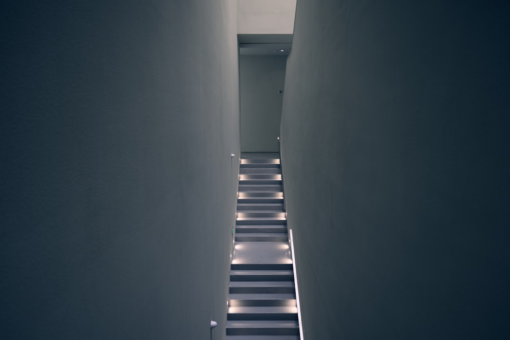 um corredor estreito com paredes brancas e piso listrado preto e branco