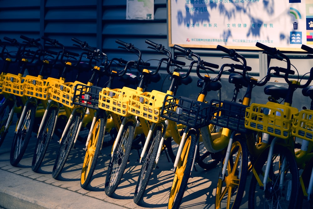 a row of yellow bicycles parked next to each other