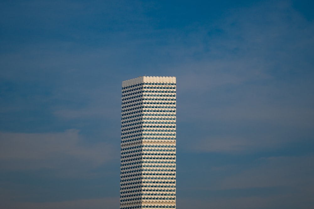 a tall white building with a sky background