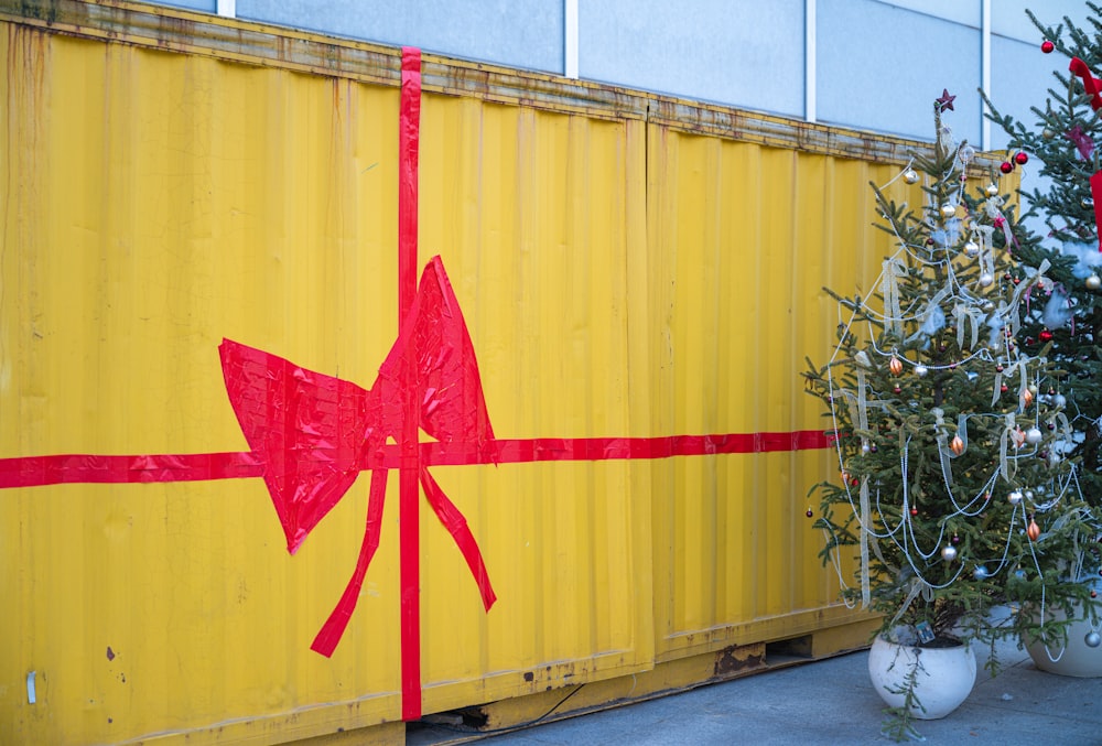 a christmas tree sitting next to a yellow container