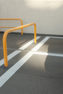Close-up of a steelguard crowd control barrier with powder-coated safety yellow finish under bright sunlight.