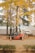 A forklift is parked on a dirt path surrounded by orange traffic cones. In the background, there are several white tents and tall trees with vibrant yellow foliage, indicative of autumn. The ground is covered with fallen leaves, adding to the autumnal atmosphere.