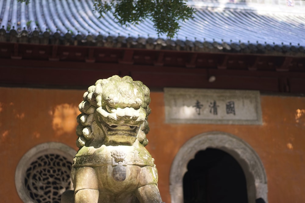 a statue of a lion in front of a building