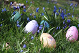A cheerful Easter Bunny handing out colorful eggs to excited children in a sunny garden