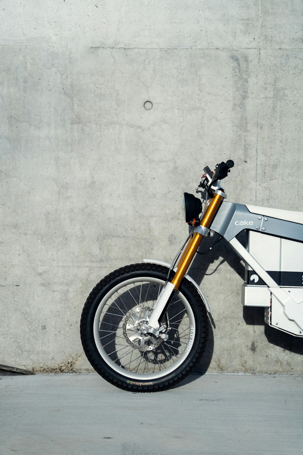 a motorcycle parked next to a cement wall