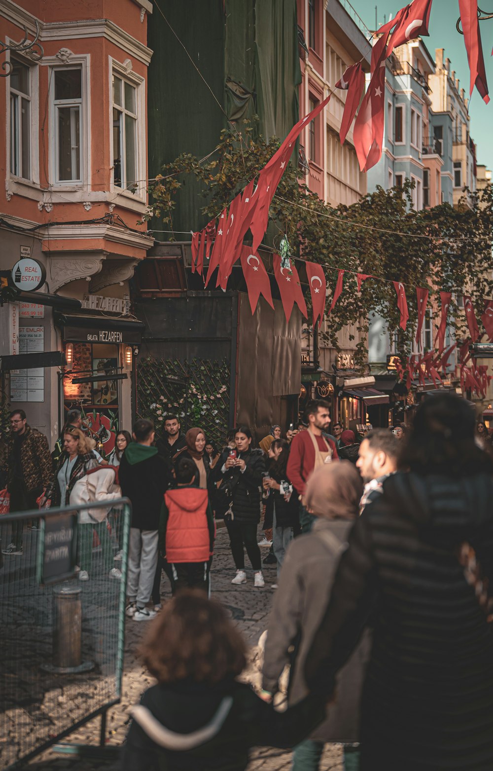 a crowd of people walking down a street next to tall buildings