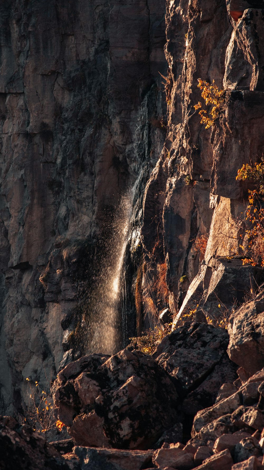 a waterfall is coming out of the side of a mountain