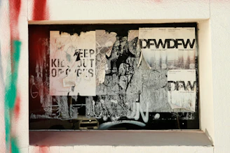 Close-up of a partially peeled propaganda poster revealing a hidden message beneath.