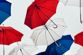a bunch of umbrellas that are in the air