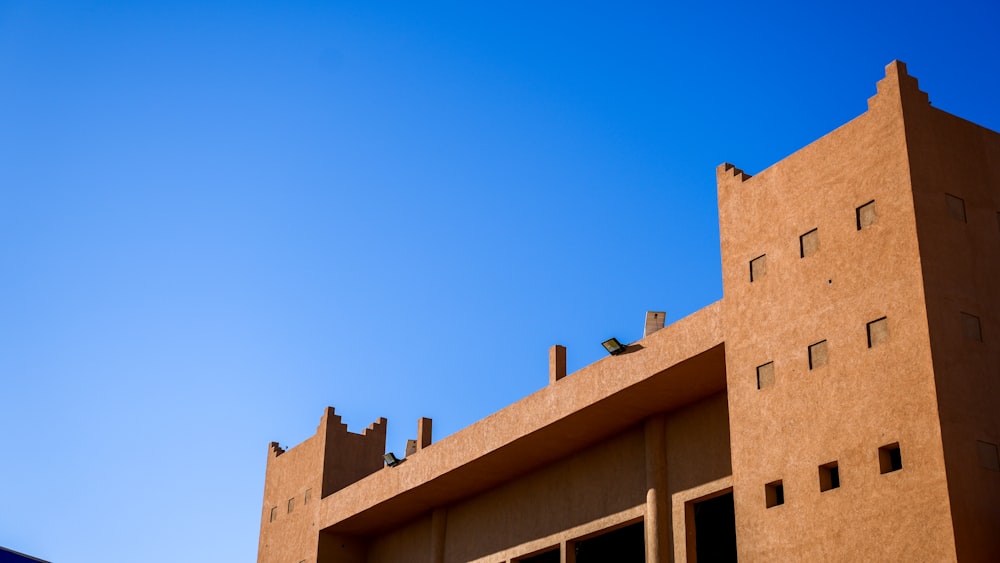 a brown building with a blue sky in the background