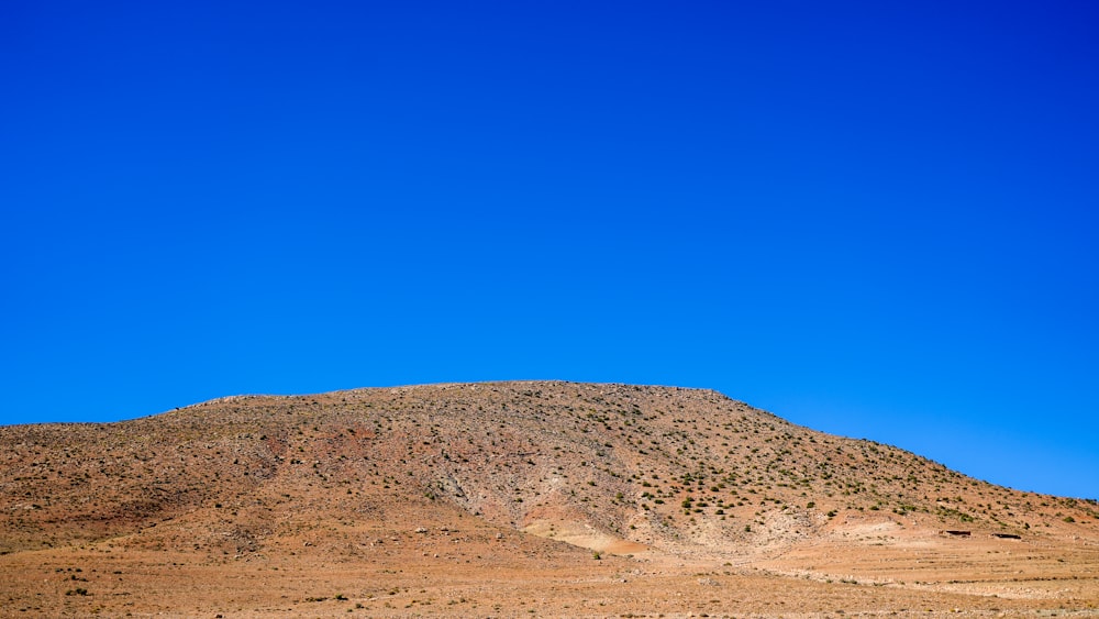 a hill with a blue sky in the background