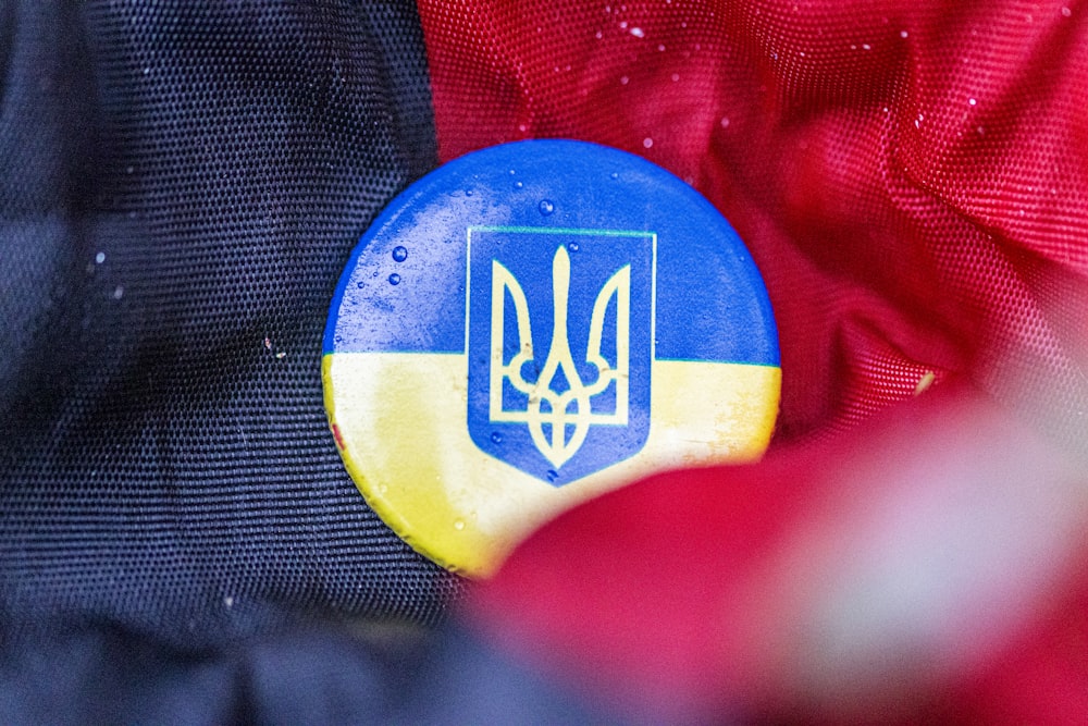a blue and yellow badge on a red jacket
