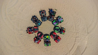 Group of friends laughing and preparing their ATVs before heading out on the beach trail.