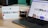 A desk with a lightbox displaying '#CHRISTMAS', a ceramic Santa figure, a black coffee mug with candy canes, and a laptop showing a webpage from Walls.io featuring various social media posts.