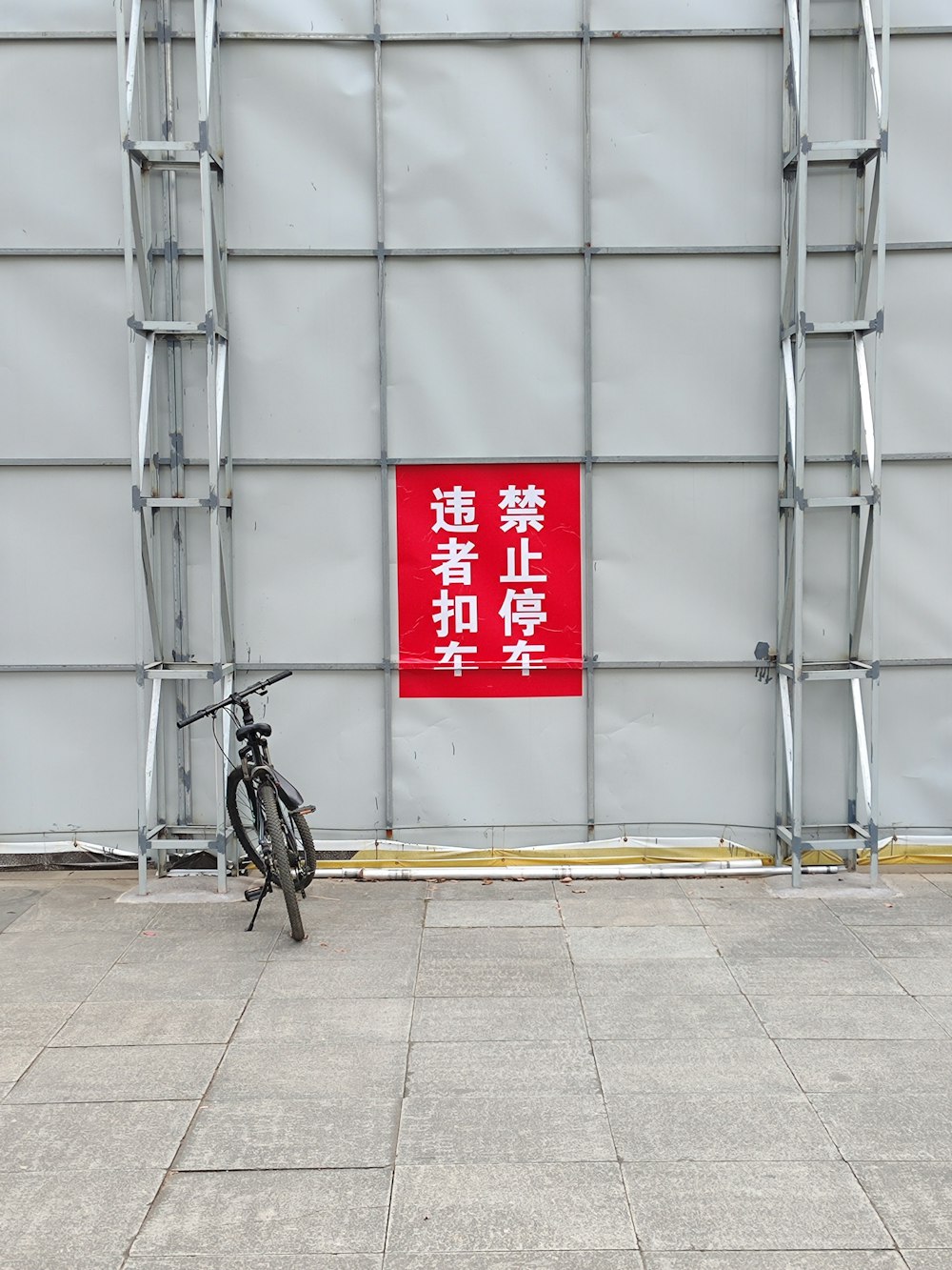 a bicycle parked in front of a building with a red sign