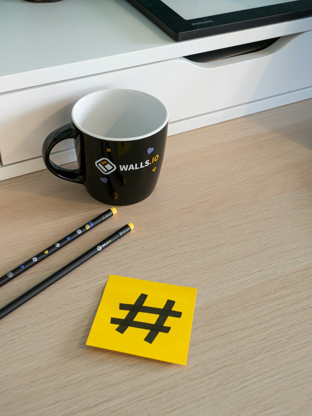 a cup of coffee and some pencils on a table