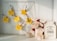 A decorative wire board displaying several yellow sticky notes, each with a handwritten campaign idea such as 'Christmas Social Media Campaign' and 'Advent Calendar Campaign'. Wooden clothespins with holiday-themed designs hold the notes. To the right of the board, a plush reindeer toy with a red scarf and hat leans against a large ceramic cookie jar labeled 'MRS. WINTERBOTTOM'S Delicious Traditions COOKIES'.