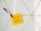 A yellow sticky note with the handwritten text 'Influencer Holiday Takeovers' is attached to a geometric wire grid. A decorative clothespin with a red and white pattern and a red pom-pom holds the note in place.