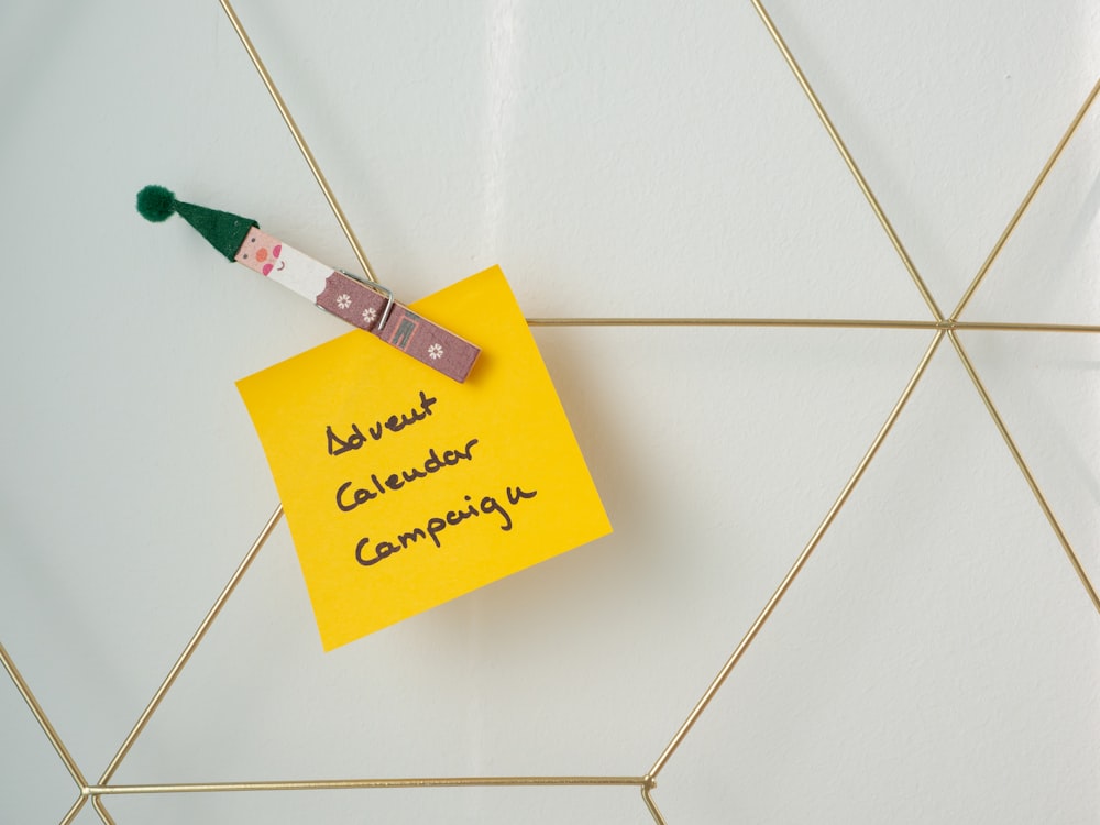 a sticky note attached to a wall with a pen