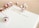A planner or journal is open to a page showing Thursday the 19th and Friday the 20th. The pages are decorated with pink and silver Christmas ornaments scattered across a light wooden surface. The handwritten text on the page reads 'Influencer Holiday Takeovers'.