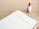 An open planner shows a page dated for Monday and Tuesday with the text 'Christmas Social Media Campaign' handwritten on it. A small figurine of a gnome with a red hat and white beard stands next to the planner on a wooden surface.