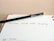 A black pencil with a yellow eraser lies diagonally across an open planner, with the words 'Christmas Social Media Campaign' written on one of the lined pages. The date 'Tuesday 10' is visible at the bottom of the page.