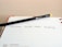 A black pencil with a yellow eraser lies diagonally across an open planner, with the words 'Christmas Social Media Campaign' written on one of the lined pages. The date 'Tuesday 10' is visible at the bottom of the page.